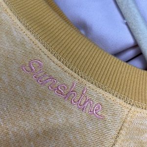 Light yellow crew neck with embroidered neckline and sleeve